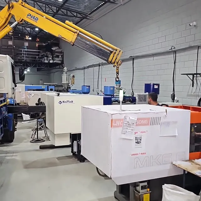 Chão de fábrica da HCPLAST: injetoras em operação e recebimento de uma nova máquina